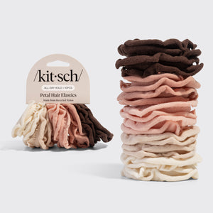 Stack of Kitsch Blush Petal Hair Elastics in cream, beige, blush, and brown with packaging on a gray background