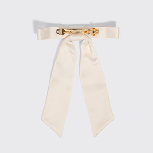 An off-white satin bow tie with a gold-tone metal clasp, displayed flat against a light gray background.