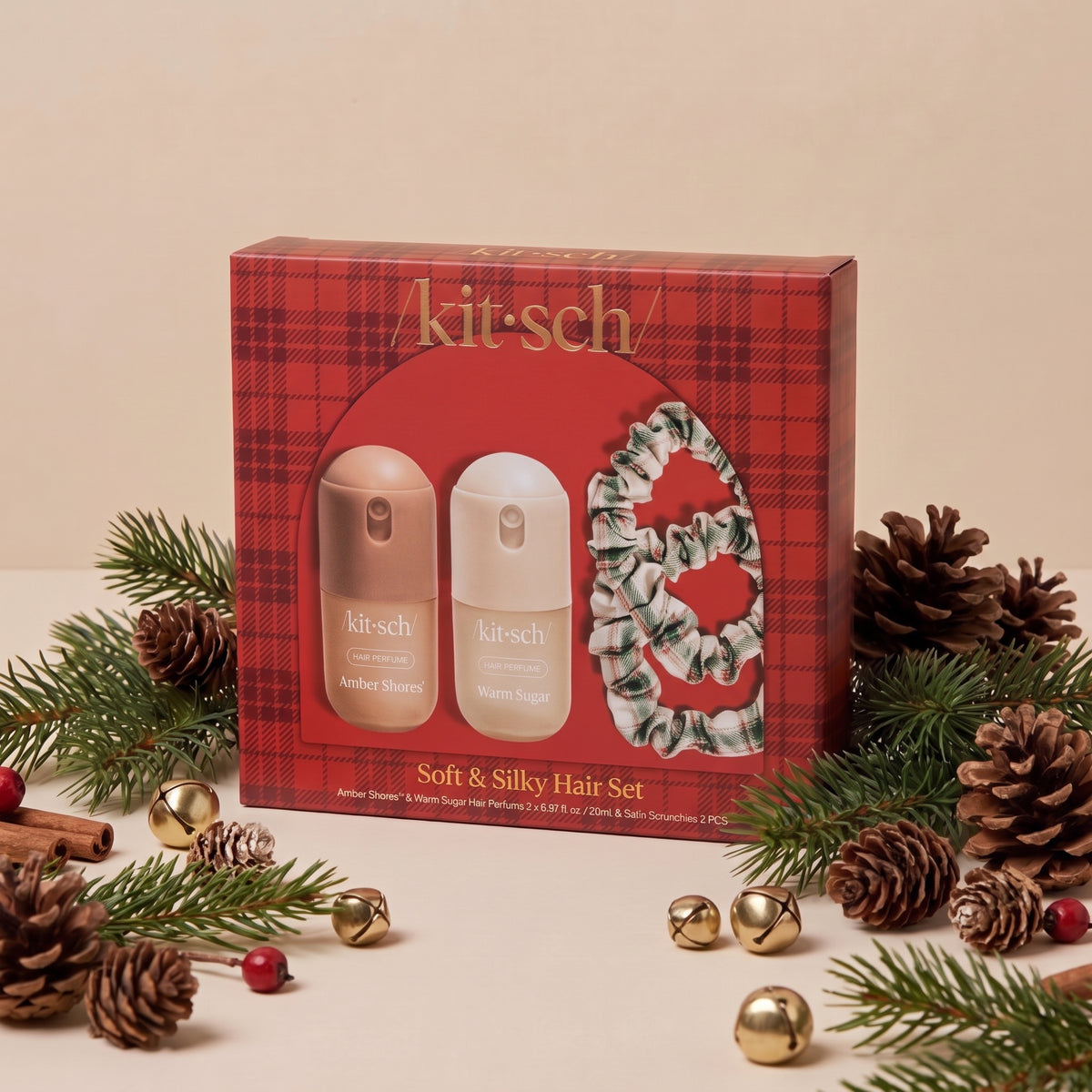 KITSCH Soft & Silky Hair 4pc Set — red plaid gift box with the Amber Shores and Warm Sugar mini hair perfumes and ivory, red and green plaid satin scrunchies, styled with pine branches, pinecones, cinnamon sticks, red berries and gold jingle bells on a cream backdrop — the season's cutest accessories — find a little something special for everyone on your list