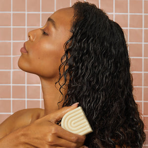 Lifestyle styling of Kitsch Coconut Oil Shampoo & Conditioner Bar Combo with palm and coconut props